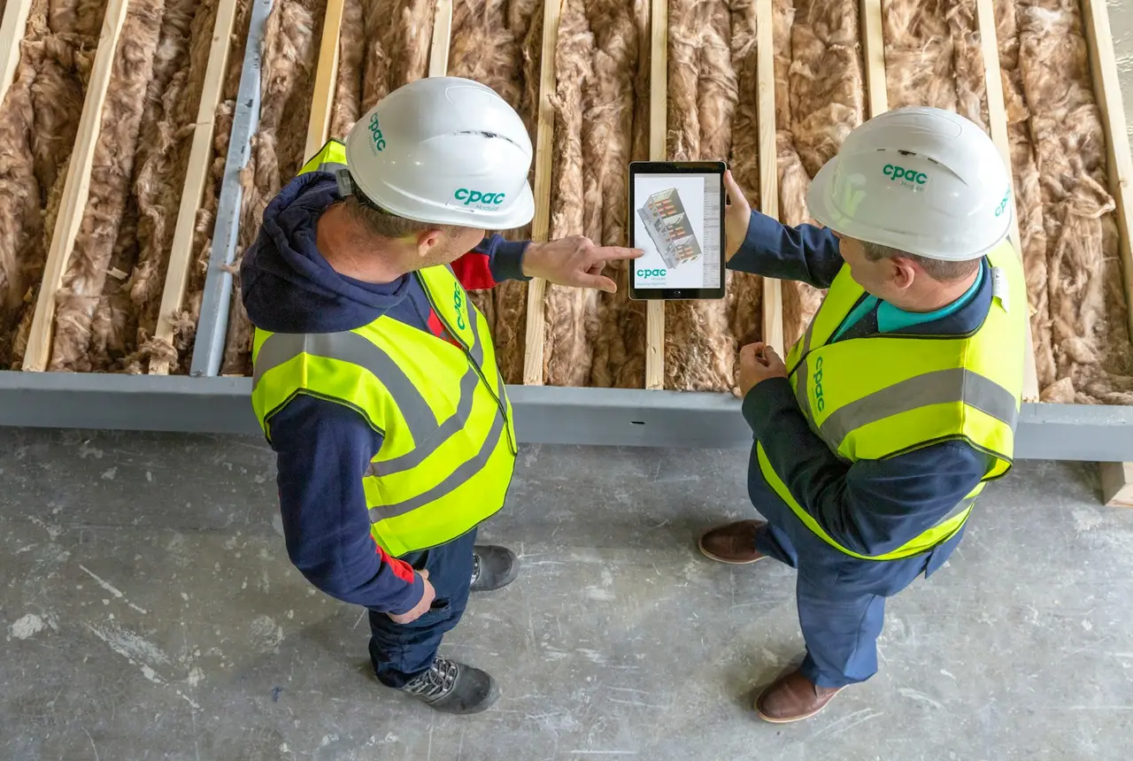 Dos trabajadores de la construcción revisando planos en una tablet